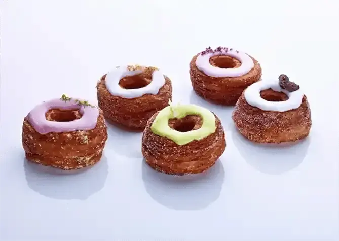 Studio shot showing five of Dominque Ansel’s cronut pastries on a table.